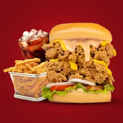 a large burger with fries and a drink